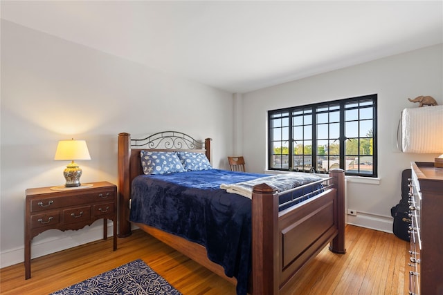 bedroom featuring light wood-style floors and baseboards