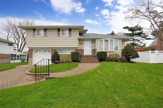 split level home featuring fence, a garage, a front lawn, and brick siding