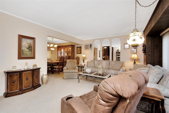 carpeted living area with ornamental molding, a wall unit AC, and a chandelier
