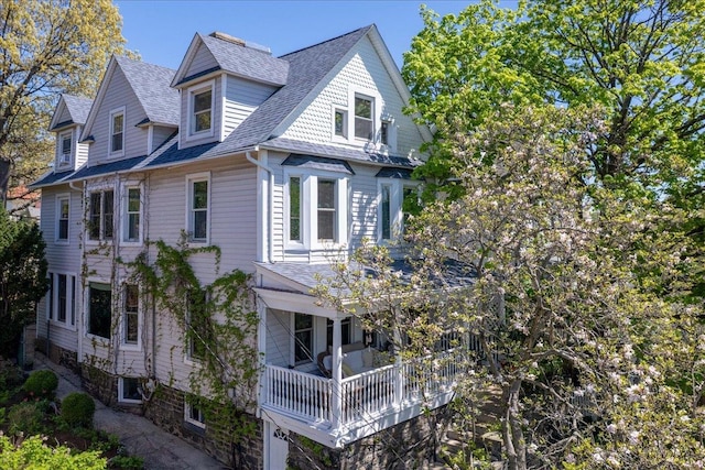 view of side of property featuring a shingled roof