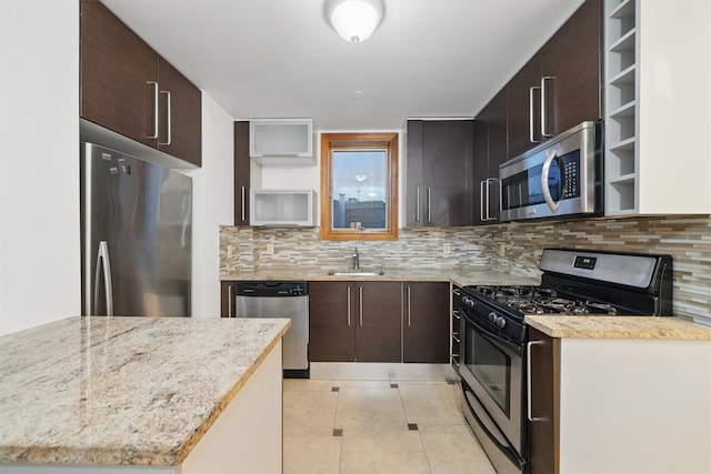 kitchen with dark brown cabinetry, light stone countertops, stainless steel appliances, light tile patterned floors, and backsplash