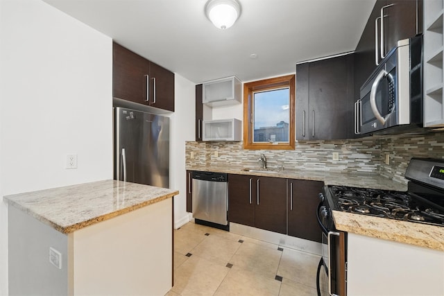kitchen with a sink, appliances with stainless steel finishes, tasteful backsplash, and open shelves