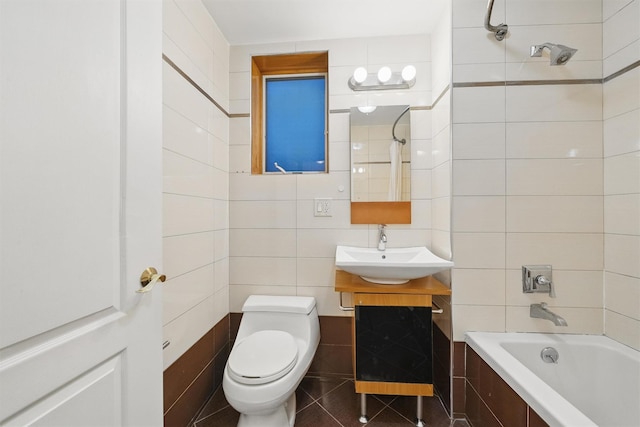 full bathroom featuring vanity, toilet, tile walls, tile patterned floors, and tiled shower / bath combo