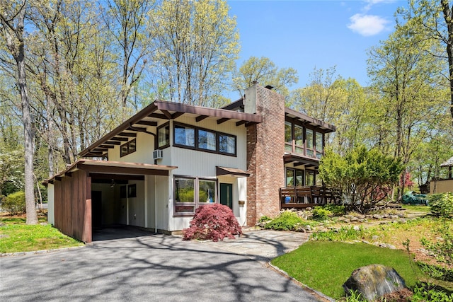 view of front of home featuring driveway and a chimney