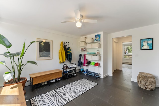 mudroom with baseboards, a baseboard radiator, ceiling fan, and dark tile patterned flooring
