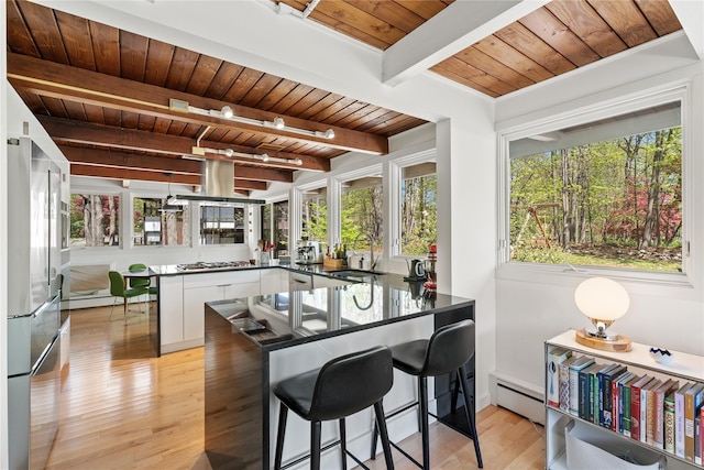 kitchen with a sink, wooden ceiling, dark countertops, and a peninsula