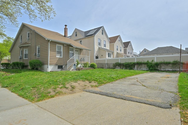 view of home's exterior with a lawn, fence, and a residential view