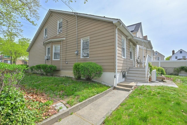 view of side of property with fence and a yard
