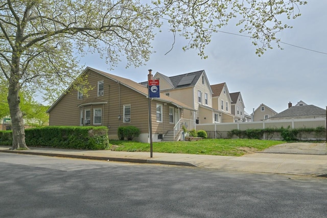 view of side of home with a chimney, fence, and a residential view