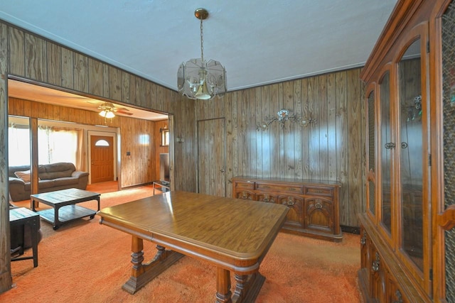 office area with carpet, wood walls, and a notable chandelier