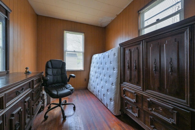 office area with wood-type flooring, plenty of natural light, and wooden walls