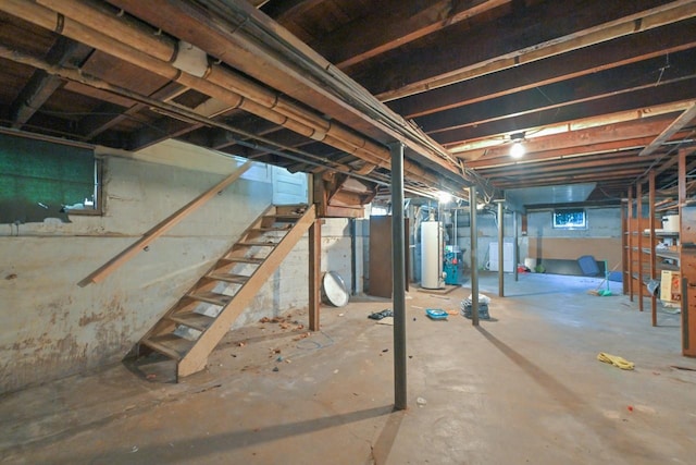 basement featuring water heater, stairway, and washer / dryer