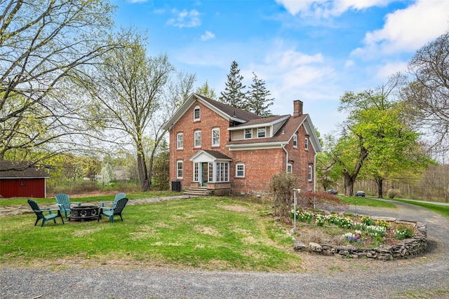 353 Berea Rd, Walden, NY 12586 - traditional-style house featuring brick siding, a fire pit, a front yard, and a chimney