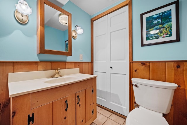 353 Berea Rd, Walden, NY 12586 - bathroom featuring wooden walls, vanity, toilet, tile patterned floors, and a wainscoted wall