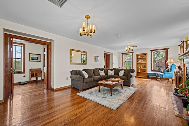 353 Berea Rd, Walden, NY 12586 - living room with a fireplace with raised hearth, baseboards, a chandelier, and wood finished floors