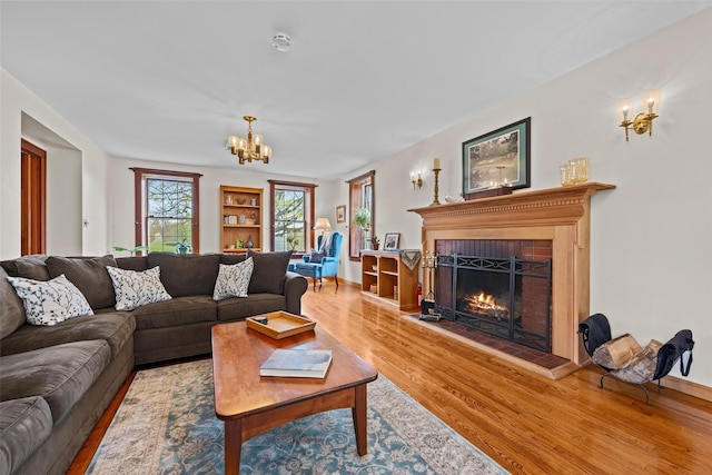 353 Berea Rd, Walden, NY 12586 - living area featuring baseboards, a fireplace, wood finished floors, and a chandelier