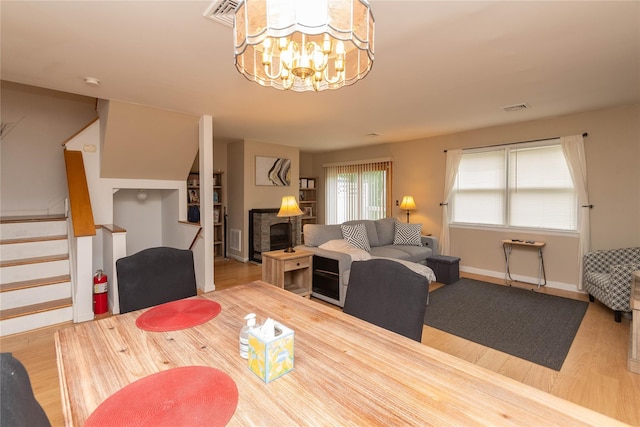 207 Cornwall Meadows Ln, Patterson, NY 12563 - dining area with wood finished floors, stairs, a chandelier, and baseboards