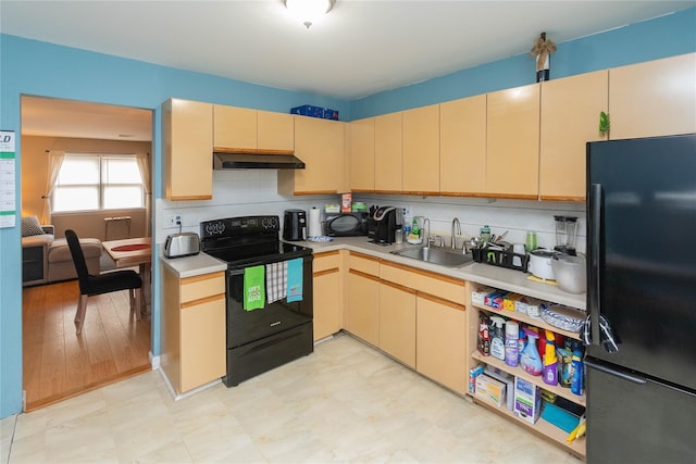 207 Cornwall Meadows Ln, Patterson, NY 12563 - kitchen with black appliances, under cabinet range hood, a sink, light countertops, and decorative backsplash