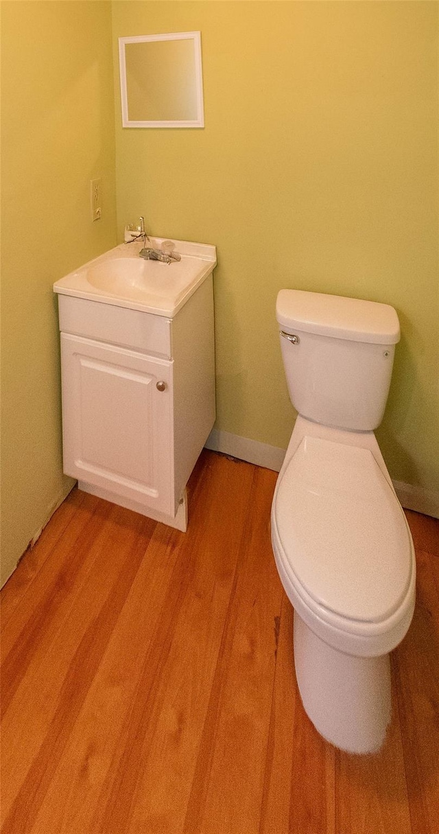 207 Cornwall Meadows Ln, Patterson, NY 12563 - half bathroom featuring toilet, vanity, wood finished floors, and baseboards