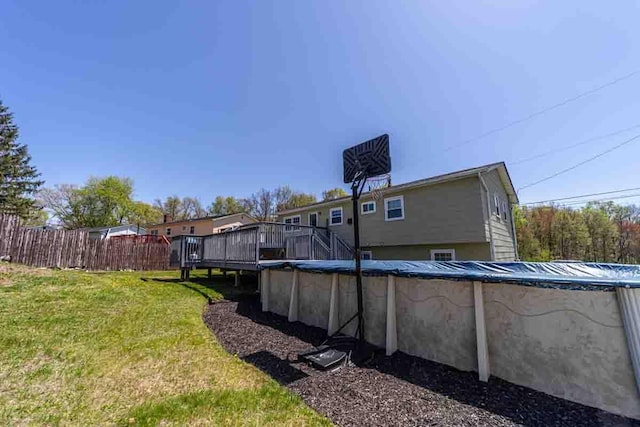 148 Chandler Ln, Montgomery, NY 12549 - back of property featuring a lawn, fence, a deck, and a covered pool