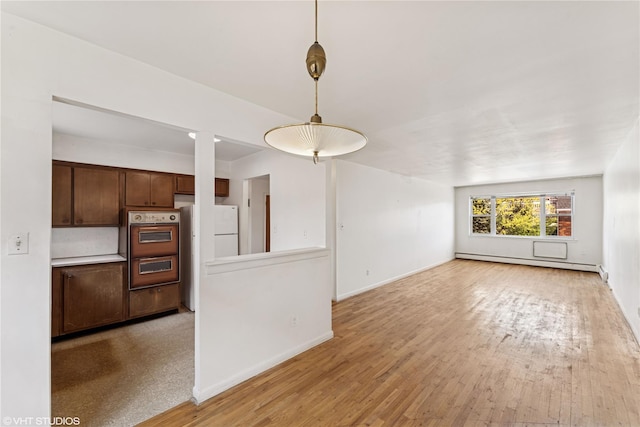 unfurnished living room with baseboards, light wood-style flooring, and baseboard heating
