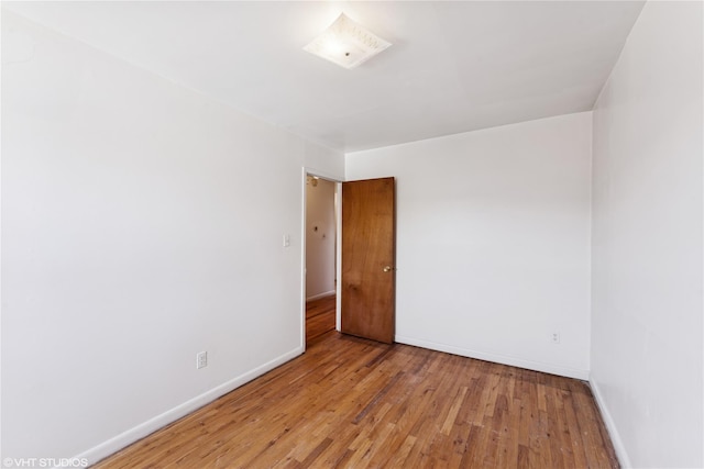 empty room featuring baseboards and wood finished floors