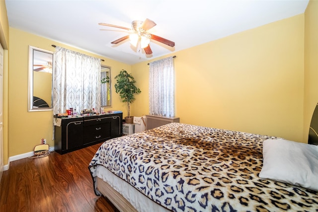 bedroom with baseboards, a ceiling fan, and dark wood-style flooring