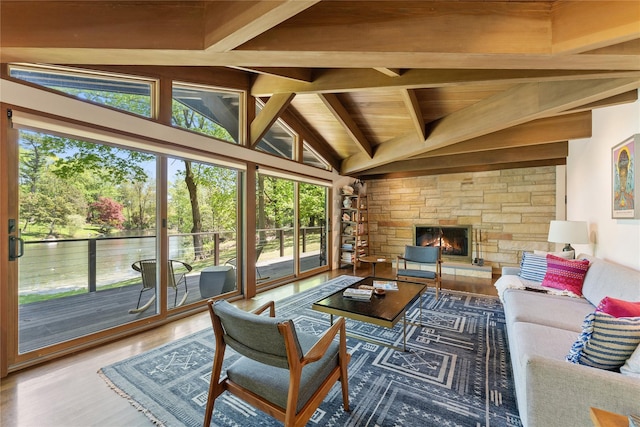 living room featuring a stone fireplace, lofted ceiling with beams, wood ceiling, and wood finished floors