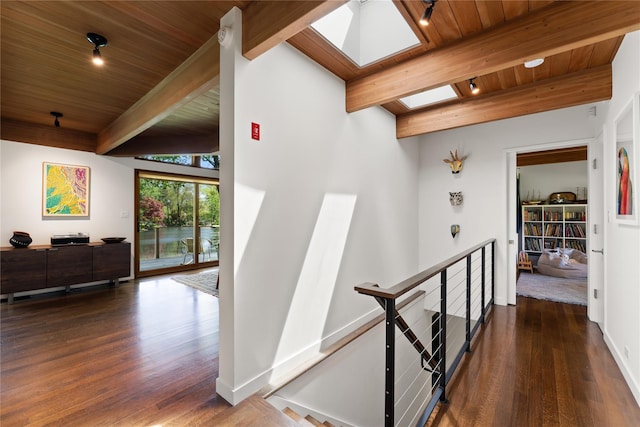 hall with wood ceiling, a skylight, wood finished floors, beamed ceiling, and an upstairs landing