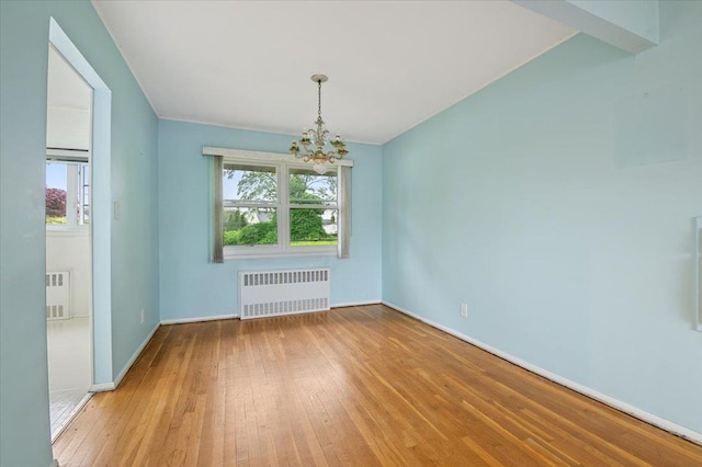 unfurnished dining area with radiator, a notable chandelier, hardwood / wood-style floors, and a wealth of natural light