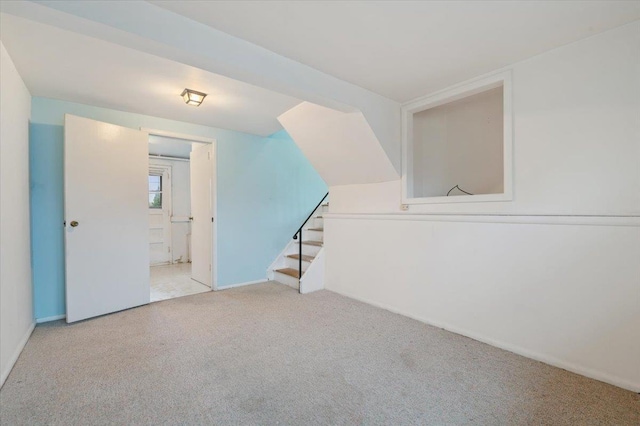 interior space with baseboards, stairway, and carpet