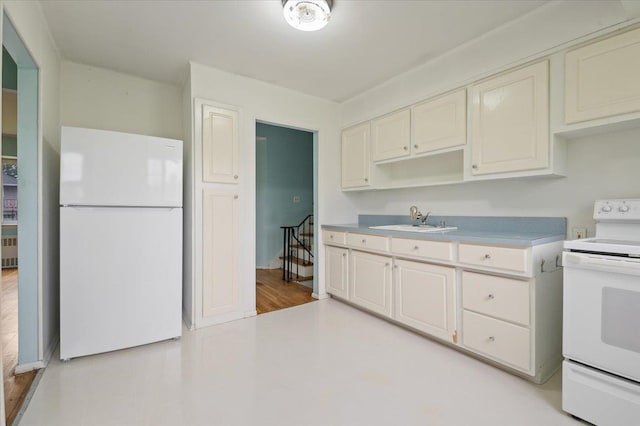 kitchen with a sink, white appliances, and light countertops