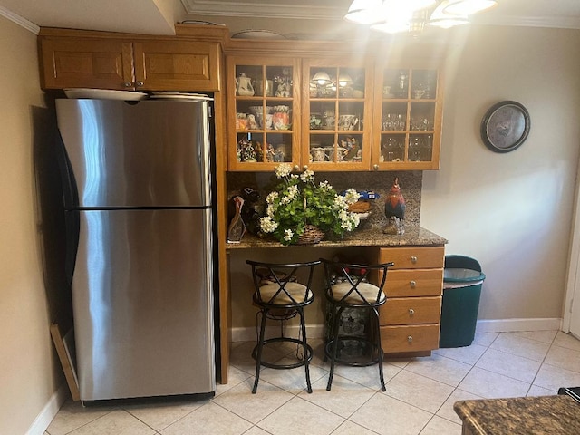 84-08 164th Ave, Howard Beach, NY 11414 - kitchen with brown cabinetry, glass insert cabinets, ornamental molding, and freestanding refrigerator