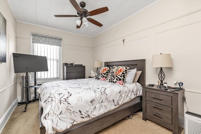 bedroom featuring ceiling fan, a decorative wall, ornamental molding, and light carpet