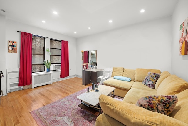 living room with recessed lighting, wood finished floors, and radiator