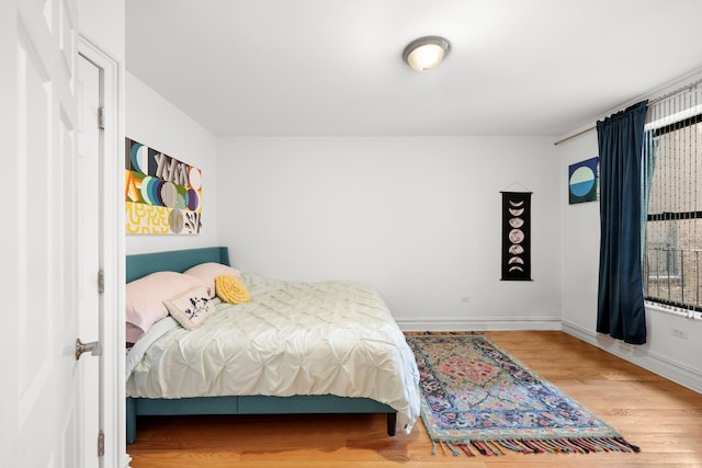bedroom featuring baseboards and wood finished floors