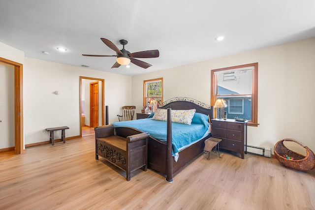 bedroom with a baseboard heating unit, recessed lighting, wood finished floors, and visible vents