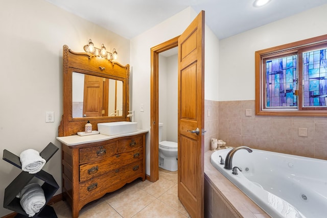 bathroom featuring a jetted tub, vanity, tile patterned flooring, and toilet