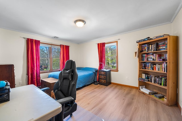 office space featuring baseboards, ornamental molding, wood finished floors, and visible vents
