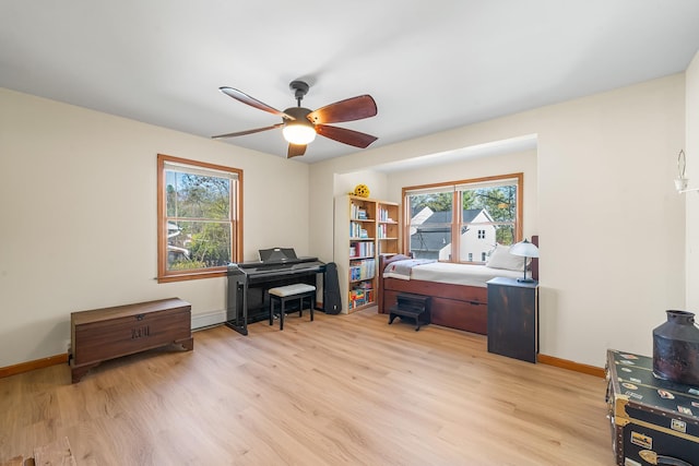 home office featuring light wood-style floors, baseboards, and ceiling fan