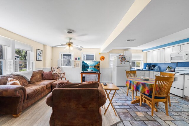 living area featuring a ceiling fan and visible vents