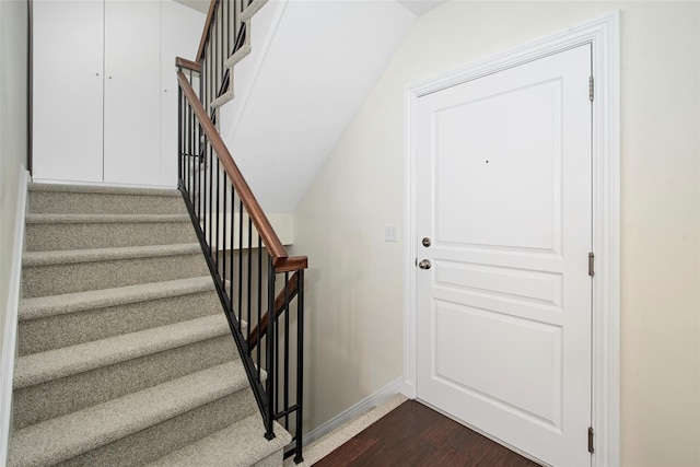 staircase with baseboards and wood finished floors