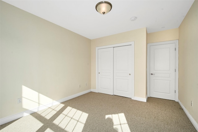 unfurnished bedroom featuring carpet floors, baseboards, and a closet