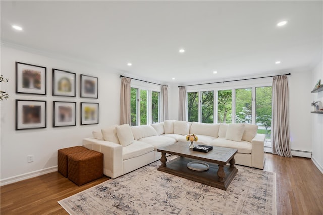 living area featuring crown molding, wood finished floors, recessed lighting, baseboards, and a baseboard radiator