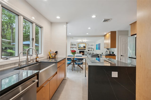 kitchen with stainless steel dishwasher, visible vents, a sink, black electric stovetop, and dark countertops