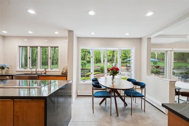 kitchen featuring dark countertops, baseboards, brown cabinets, and recessed lighting