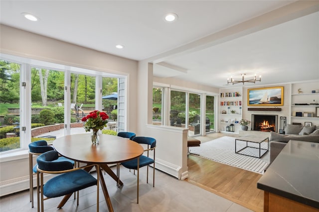 interior space featuring a warm lit fireplace, an inviting chandelier, recessed lighting, and plenty of natural light