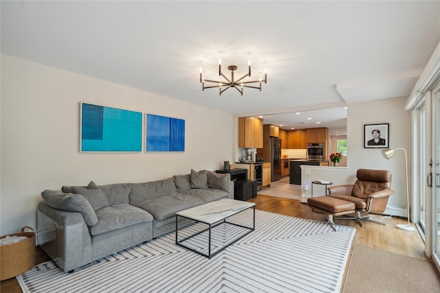 living room with a chandelier, light wood finished floors, recessed lighting, and baseboard heating
