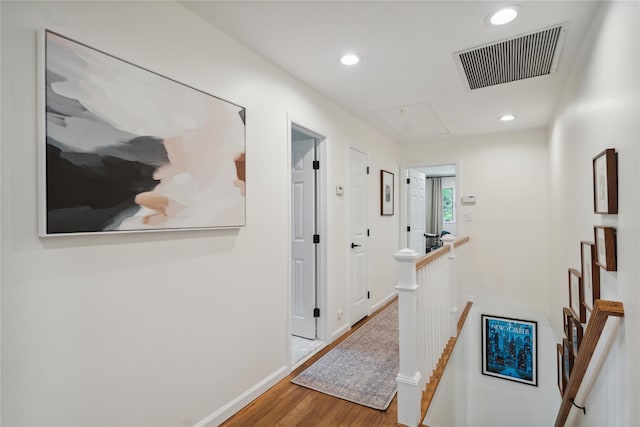 corridor featuring recessed lighting, attic access, visible vents, wood finished floors, and an upstairs landing