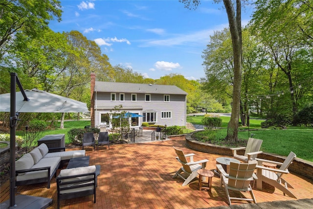 back of house featuring outdoor dining space, a yard, a chimney, an outdoor living space with a fire pit, and a patio area